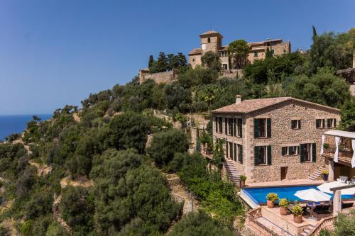 une image d'une maison sur une montagne avec une piscine dans l'établissement Villa Can Sarales - Deia, à Deià