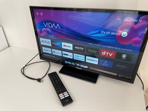 a television with a remote control and a keyboard at Kamatas STAY 京急蒲田駅 徒歩5分 in Tokyo