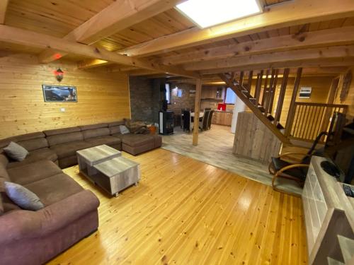 a living room with a couch and a staircase at Zaovinski Raj Tara in Konjska Reka