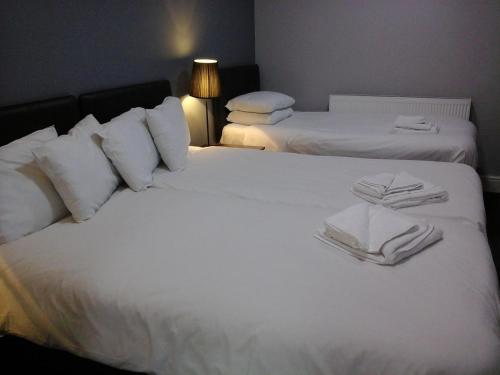a bedroom with two beds with white sheets and towels at The Liverpool Inn Hotel in Liverpool