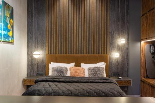 a bedroom with a large bed with a wooden headboard at Adryades luxury apartments in Metsovo