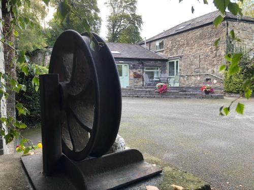 a statue of a wheel in front of a house at Hafan Cottage at Bryn Llys in Bethesda