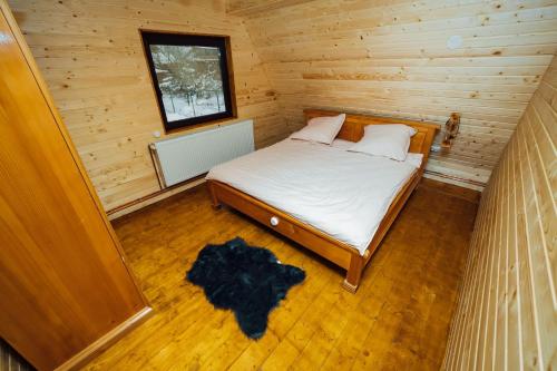 a bedroom with a bed in a wooden cabin at Finașii in Albac