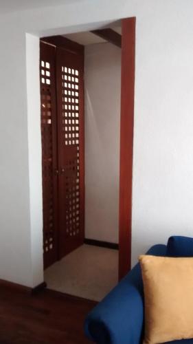 a room with a blue couch and a door at Casa Cantarranas in Tehuacán