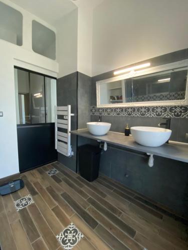 a bathroom with two sinks and a wooden floor at La vie de château in Meslay-du-Maine