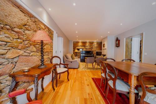 a living room with a table and a stone wall at Casa de Valcova - Boutique Hotel in Canedo