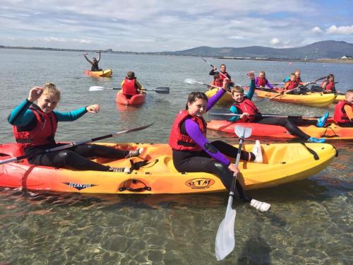 a number of people in kayaks on a body of water at East Coast Adventure Centre Glamping in Rostrevor