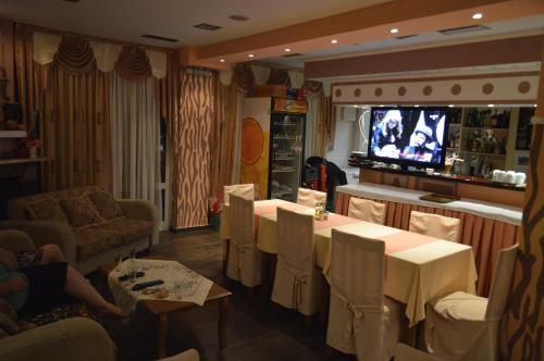 a restaurant with tables and chairs and a tv at Artemis in Paralia Katerinis