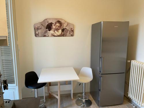 a kitchen with a white table and a refrigerator at PalazzoRegina in Pergola