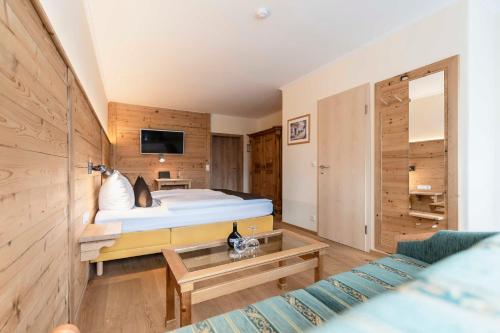 a hotel room with a bed and a couch at Hotel Bellevue in Bad Wiessee
