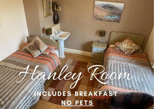 una camera da letto con due letti e un lavandino con la scritta lavanderia, animali non ammessi di Orchard Side Bed and Breakfast a Great Malvern