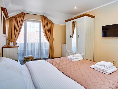 a bedroom with a large bed with two towels at Guest house Nikolaevsky in Bilhorod-Dnistrovskyi