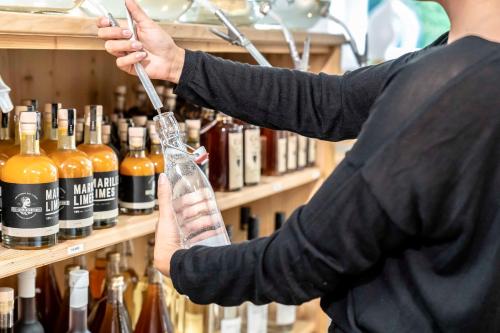 a person is holding a bottle in front of a shelf of bottles at Hotel Bellevue in Bad Wiessee