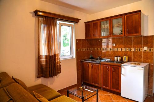 a kitchen with a white refrigerator and a window at Apartments Kordic in Budva