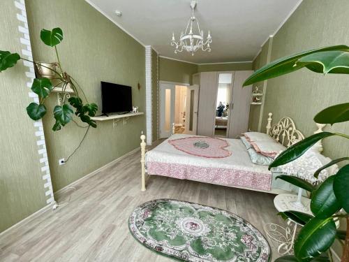 クルスクにあるGarmoniya Apartmentのベッドルーム1室(ベッド1台、シャンデリア付)