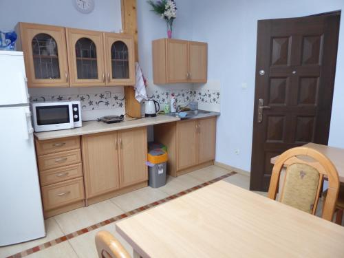 Una cocina con gabinetes de madera y un refrigerador blanco. en Willowe Zacisze, en Polanica-Zdrój