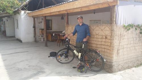 a man is standing next to his bike at Guest House KAGAN in Toktogul