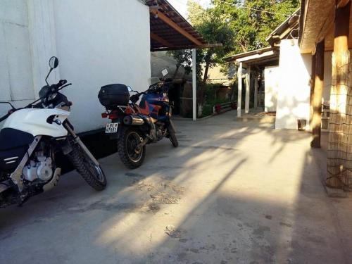 two motorcycles are parked next to a building at Guest House KAGAN in Toktogul