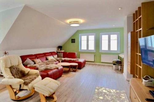 a living room with a red couch and chairs at Schöne ruhige Ferienwohnung für die ganze Familie in Risum-Lindholm