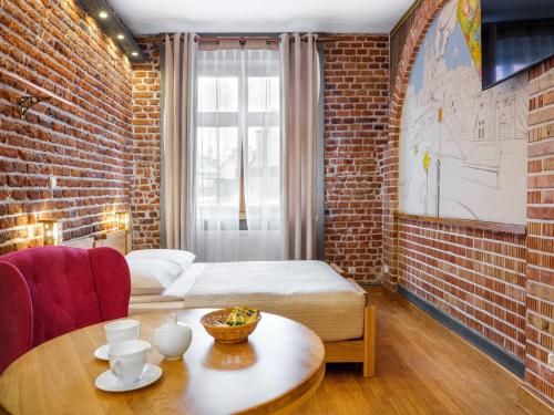 a room with a bed and a table in a room at Aparthotel Stare Miasto in Kraków