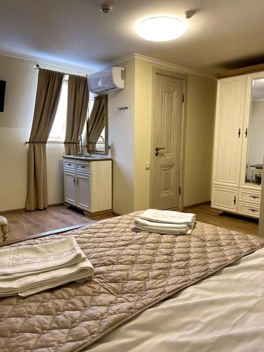a large bed in a room with a kitchen at Guest house Nikolaevsky in Bilhorod-Dnistrovskyi