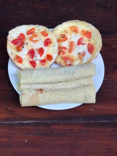 a plate of food with pizza and bread on it at Summer Time Hiriketiya in Dickwella