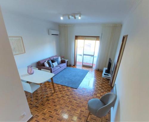 ein Wohnzimmer mit einem Sofa und einem Tisch in der Unterkunft Braga centro - apartamento espaçoso e confortável - Todas as comodidades in Braga