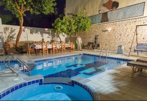ルクソールにあるAl Gezera Apartmentsの大きなスイミングプール(テーブル、椅子付)