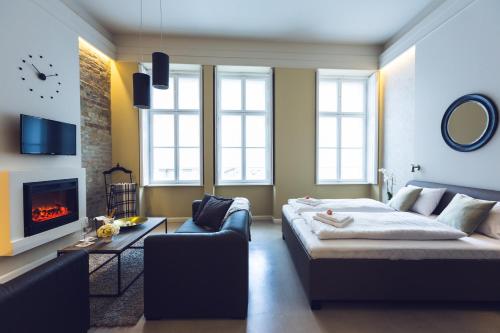 a living room with a bed and a couch and a fireplace at Heritage Home Apartments in Budapest