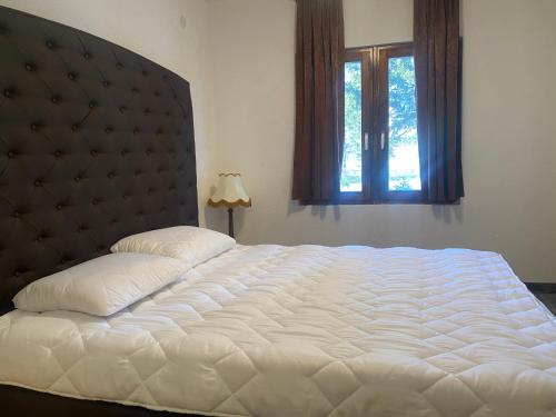 ein großes weißes Bett in einem Schlafzimmer mit Fenster in der Unterkunft LOTUS ALMANSOURi لوتس المنصوري in Kruščica