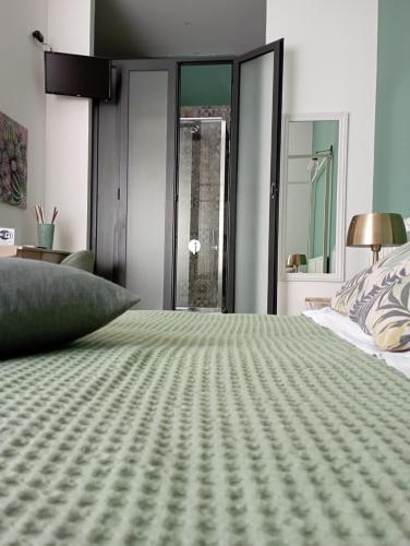 a bedroom with a bed with a green bedspread at Via Roma 315 bed and breakfast in Palermo