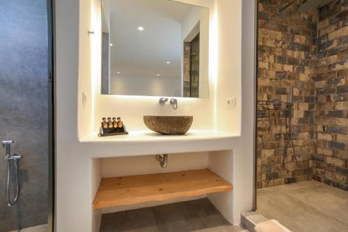 un bagno con lavandino e specchio di Petinaros Hotel a Mykonos Città