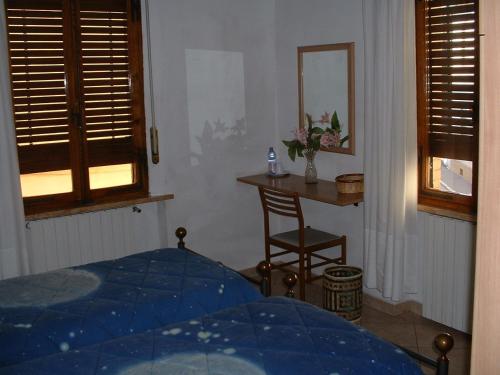 a bedroom with a bed and a table and a chair at Il Pozzo Della Citerna in Castelnuovo Berardenga