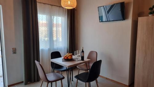a dining room with a table and chairs and a television at Secret Garden Hotel in Maleme