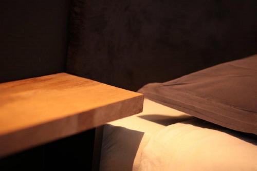 a wooden bench next to a bed with a pillow at accademia00 in Maastricht
