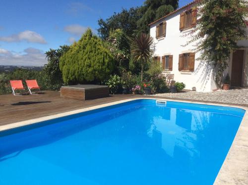 a swimming pool in front of a house at Casal dos Melros in Cruzes