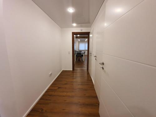 a hallway with white walls and a wooden floor at Handwerkerwohnung - Monteurunterkunft in Crumstadt
