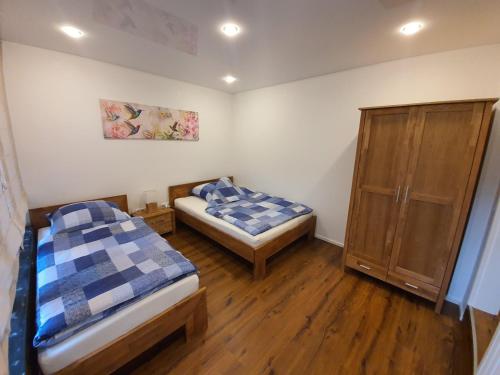 a room with two beds and a cabinet in it at Handwerkerwohnung - Monteurunterkunft in Crumstadt