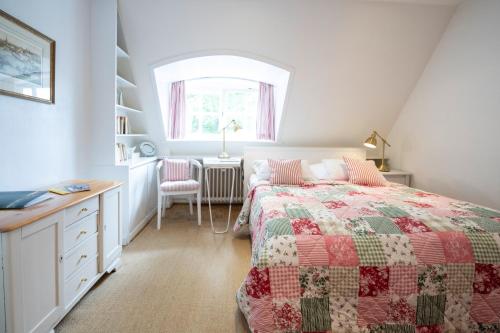 a bedroom with a bed and a desk and a window at Gut Basthorst in Basthorst