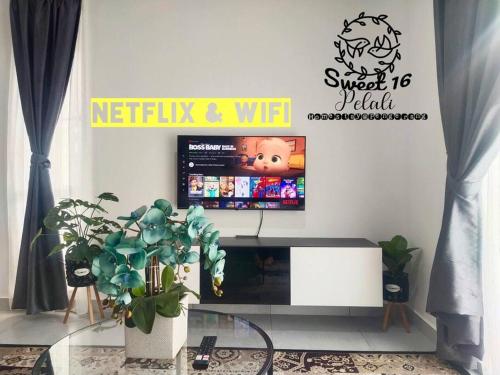a living room with a tv and a glass table at Sweet 16 Pelali Homestay Pengerang (Wifi/Netflix) in Pengerang