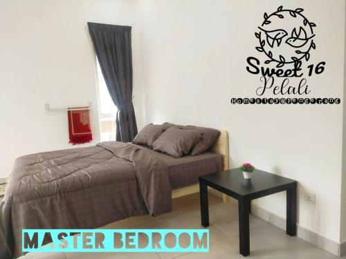 a bedroom with a bed and a table in it at Sweet 16 Pelali Homestay Pengerang (Wifi/Netflix) in Pengerang