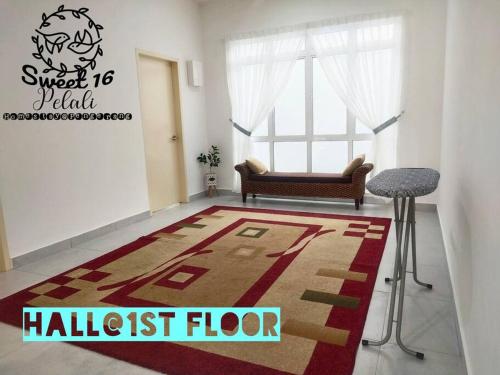 a living room with a rug and a chair and a window at Sweet 16 Pelali Homestay Pengerang (Wifi/Netflix) in Pengerang