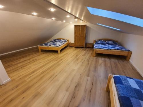 two beds in a room with wooden floors at Handwerkerwohnung - Monteurunterkunft in Crumstadt