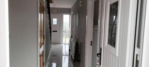 a hallway with white walls and a white door at Willowfarmhouse in Milford