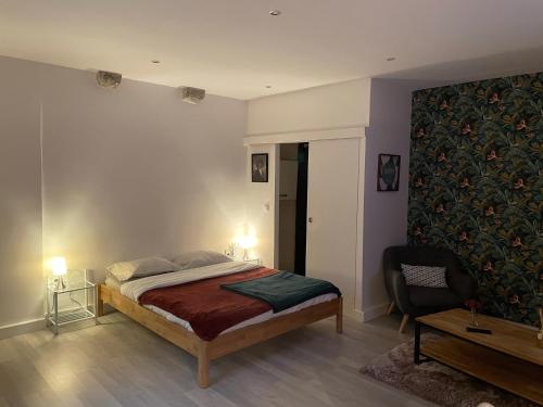 - une chambre avec un lit et une chaise dans l'établissement Le Relais Du Petit Lion, à Blois