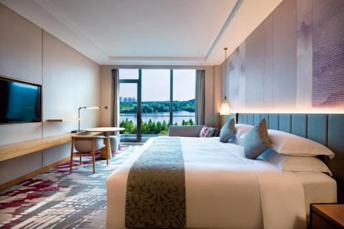 a hotel room with a large bed and a television at Crowne Plaza Huzhou by IHG in Huzhou