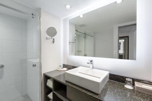 a white bathroom with a sink and a mirror at Crowne Plaza San Jose La Sabana by IHG in San José