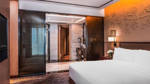 a bedroom with a bed and a sliding glass door at InterContinental Fuzhou in Fuzhou
