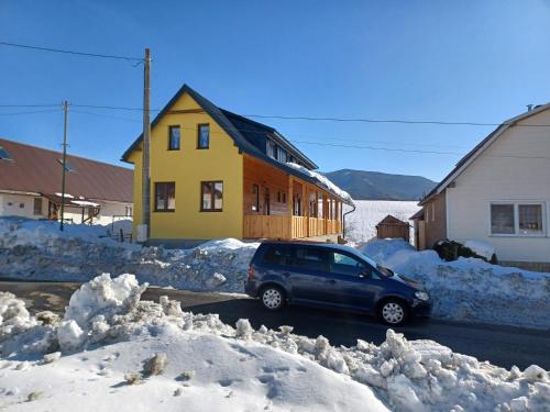 un coche aparcado frente a una casa en la nieve en Turistický apartmánový domček Runina 11, en Runina