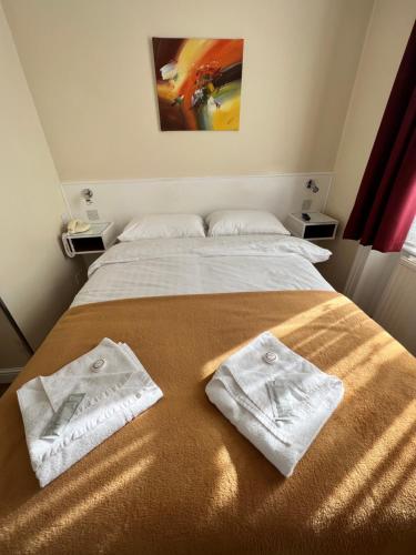 a bed with two white towels on top of it at Melbourne House Hotel in London